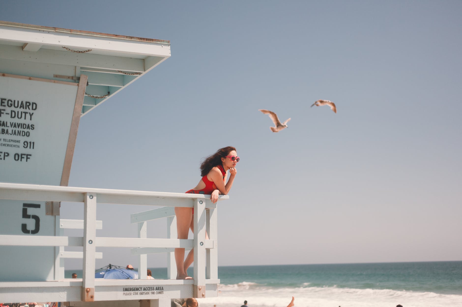 photo of woman leaning on wooden fence