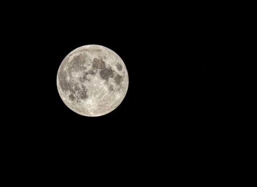 luminous full moon on dark sky