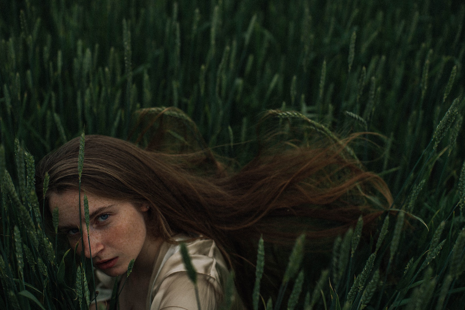 Woman in White Shirt Standing on Green Grass Field