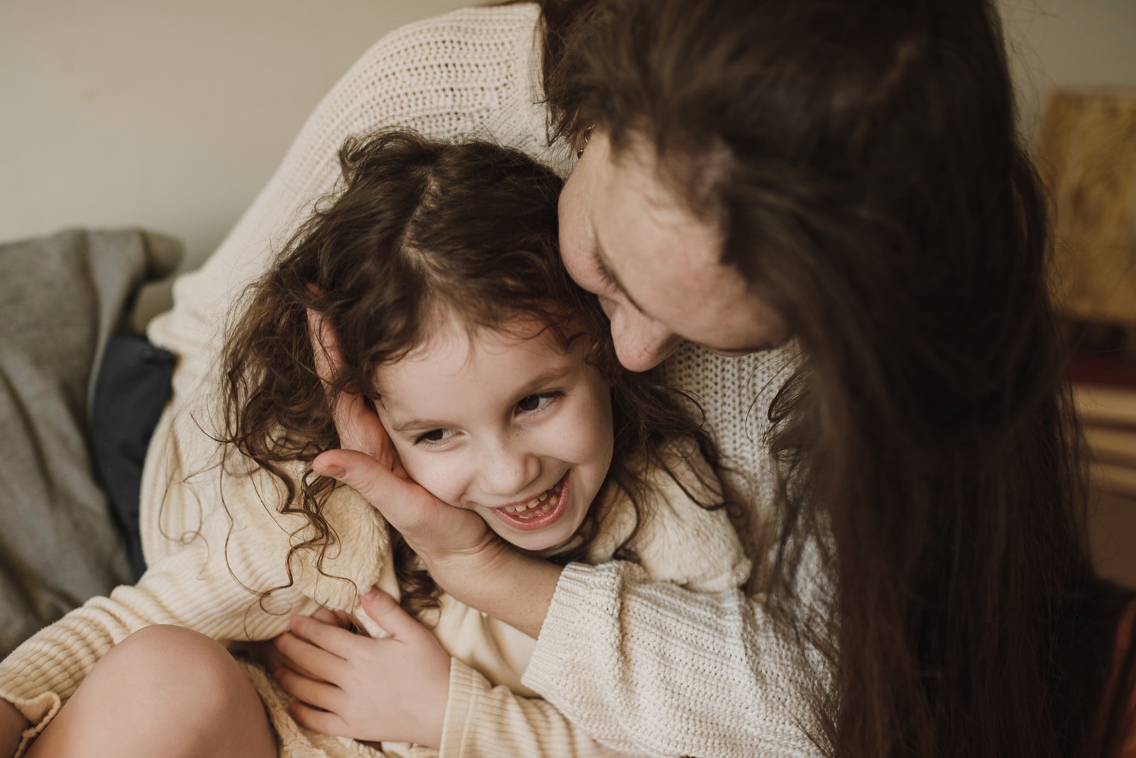 Woman in Beige Sweater Hugging Her Daughter