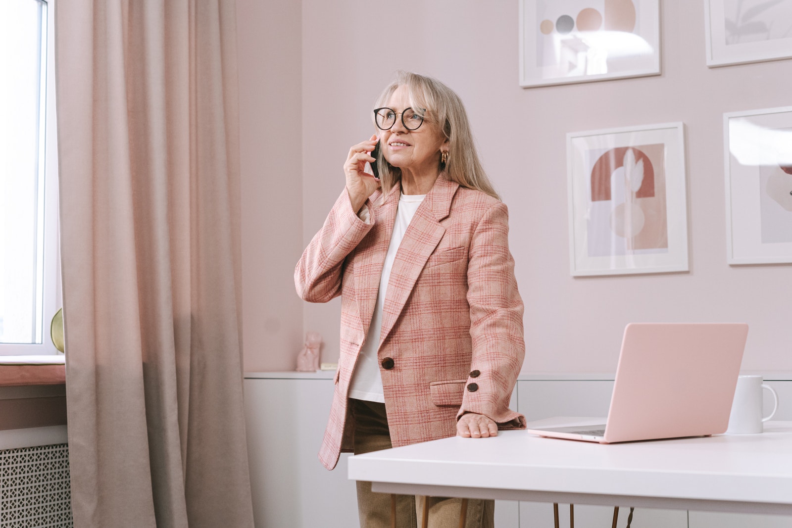 An Elderly Woman Standing while Talking on the Phone