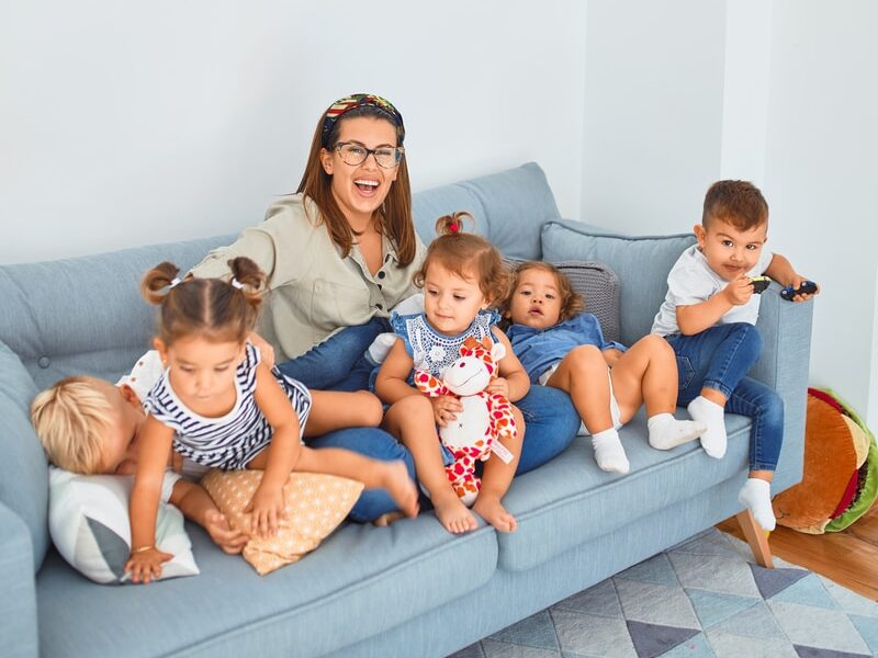 3 women sitting on gray couch