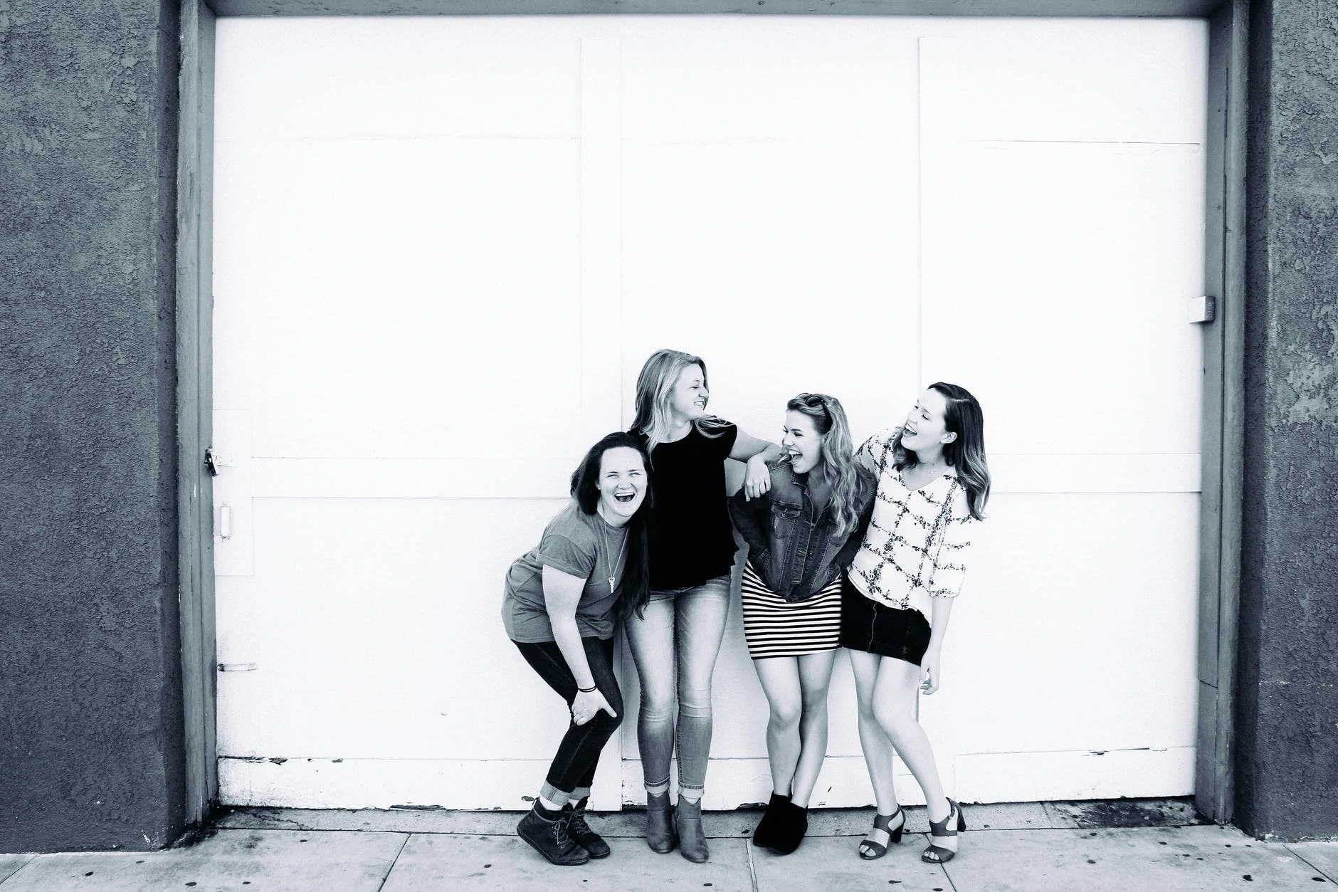 grayscale photography of four women wearing clothes