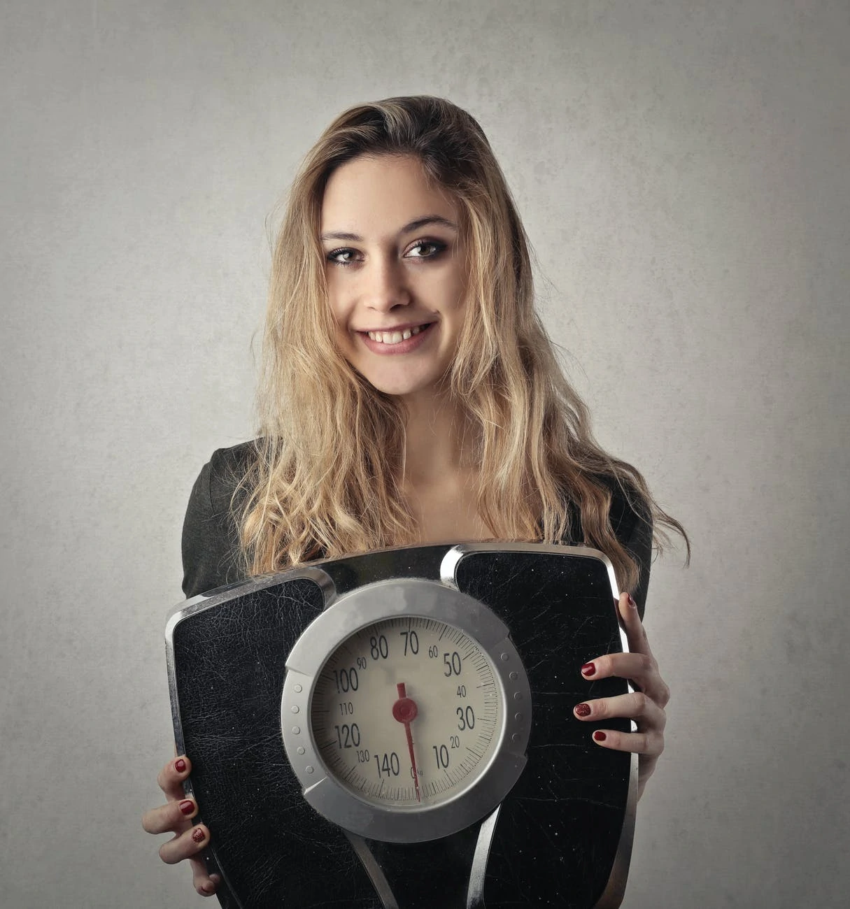 woman in black shirt holding black and silver weight scale