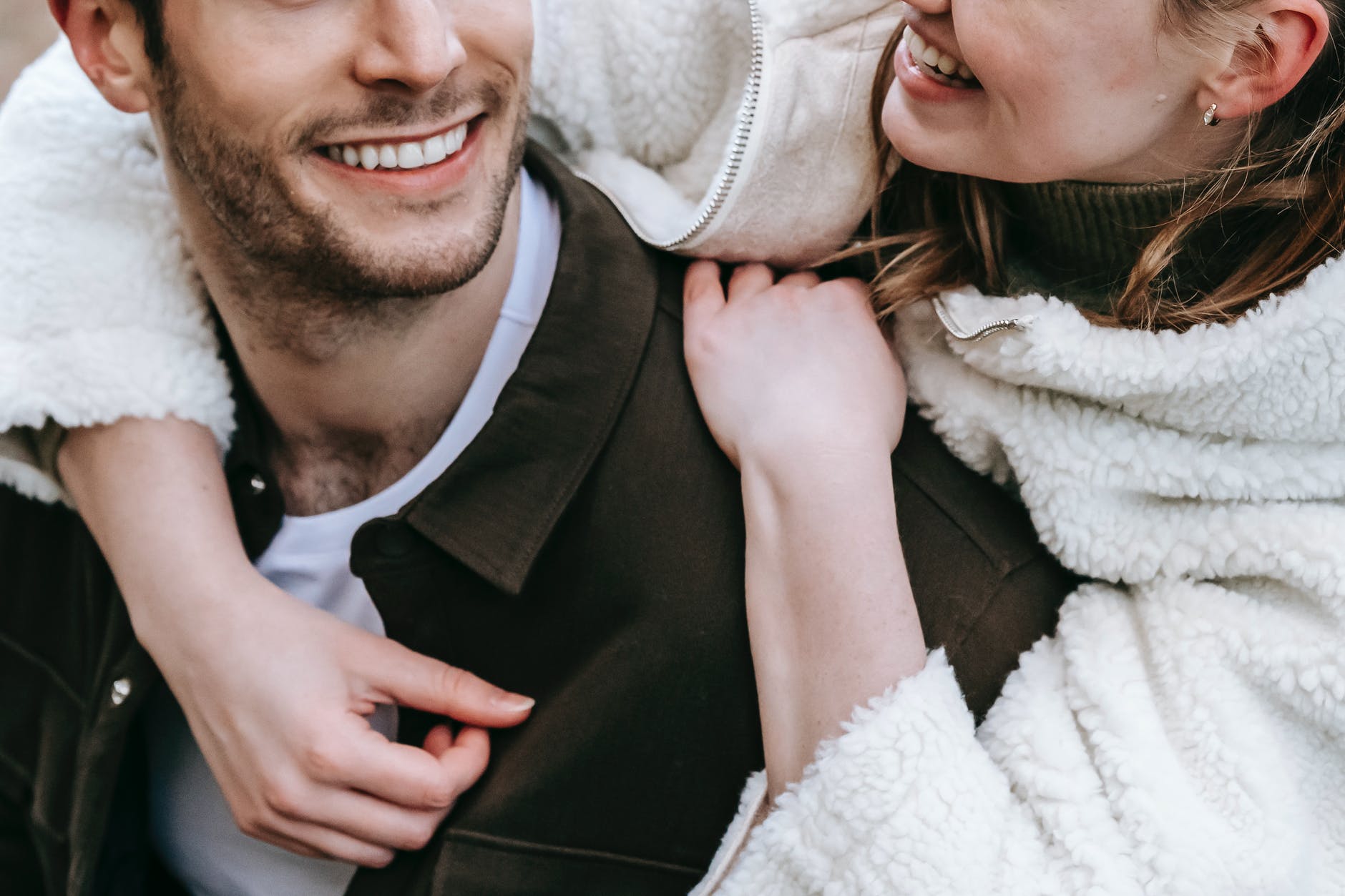 cheerful smiling girlfriend embracing positive boyfriend