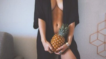 women holding pineapple while standing