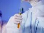 A Person Holding a Test Tube with Yellow Chemical and Syringe