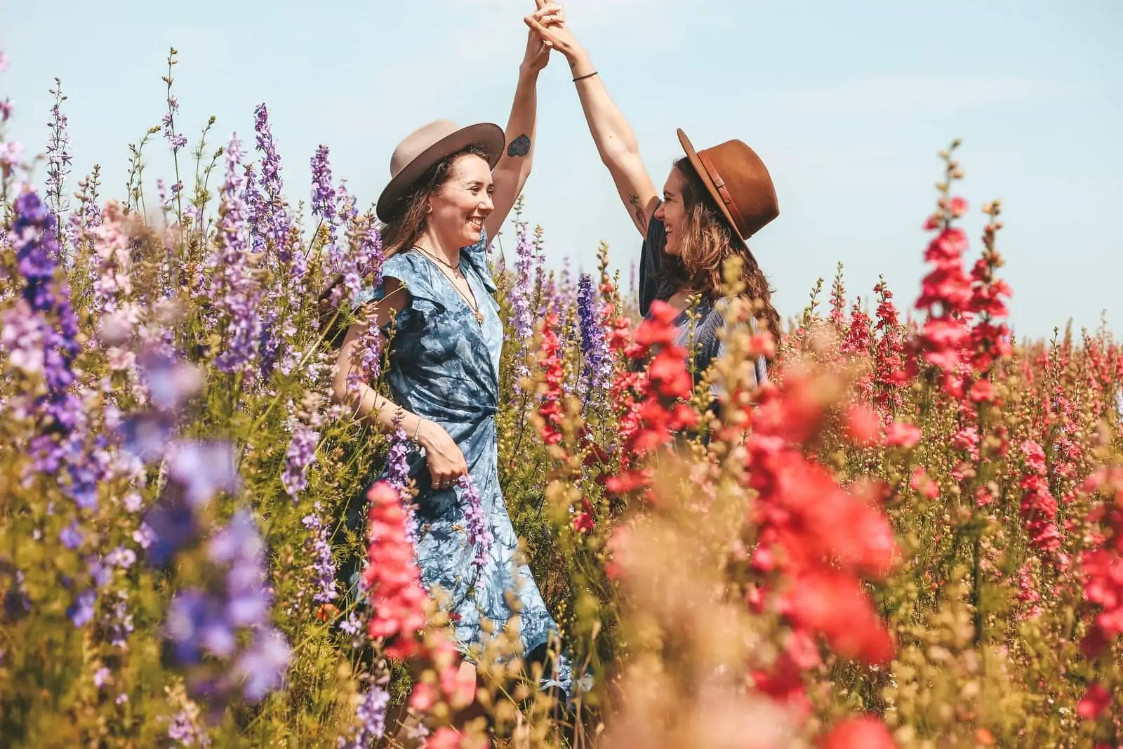 two women holding hands at the flower field