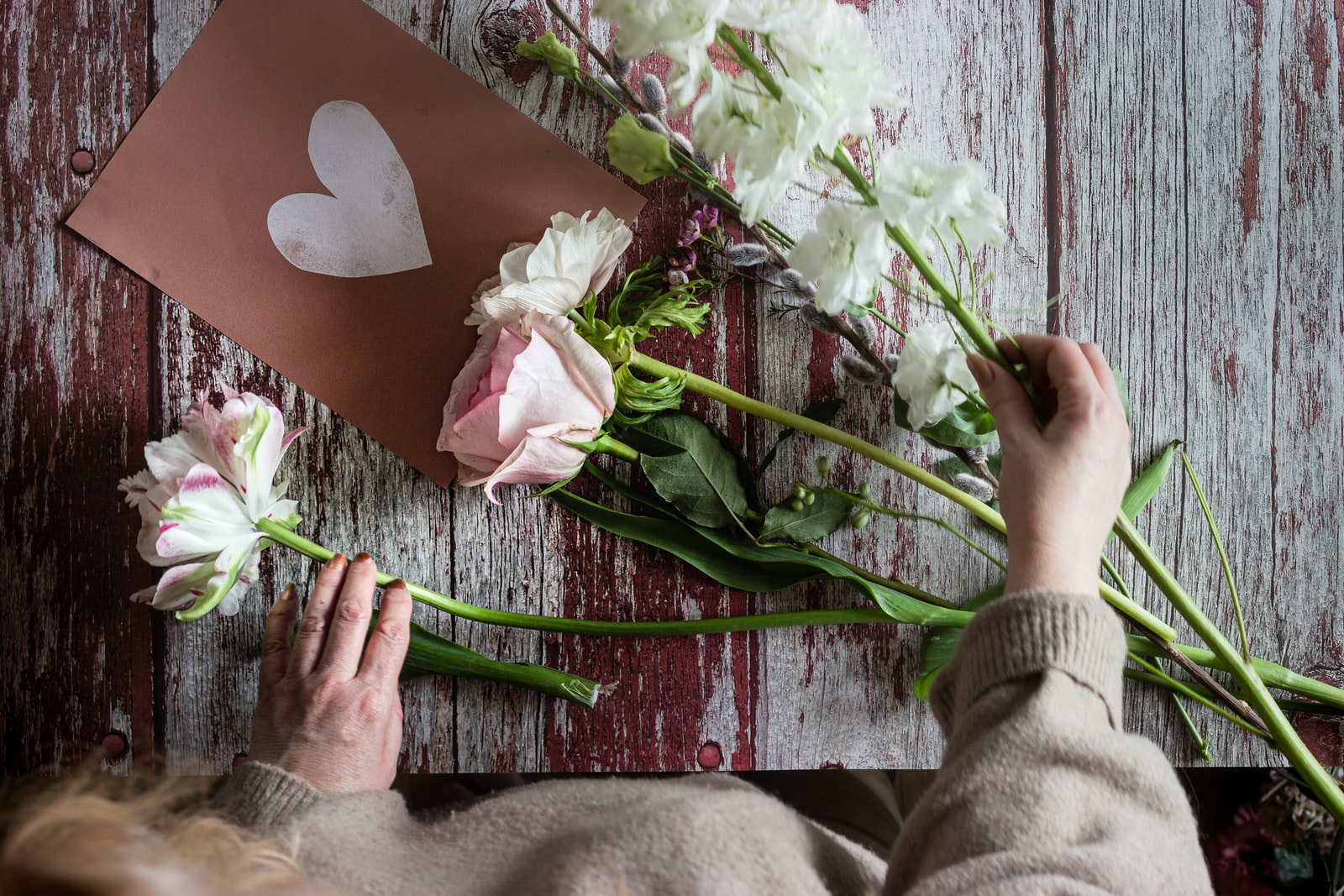 person holding white and pink flower bouquet