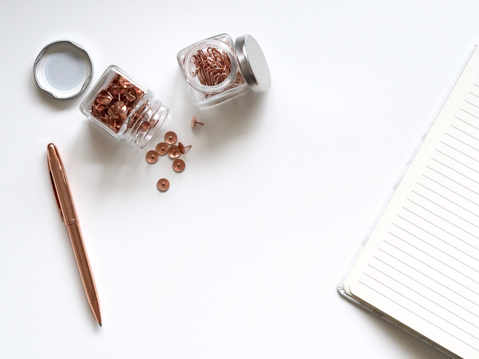 stainless steel twist pen beside clear glass jars