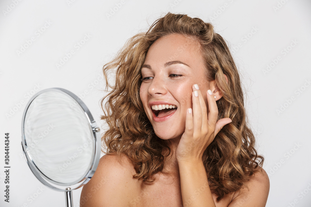 Image of excited half-naked woman smiling and looking at mirror