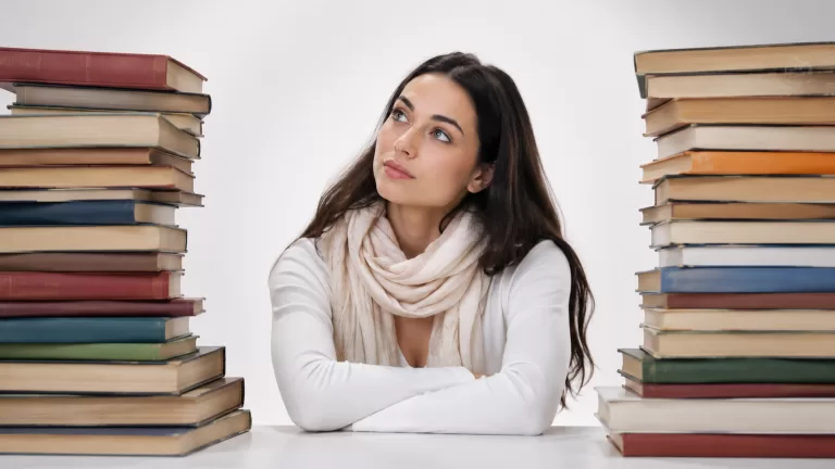 Девушка среди стопок книг