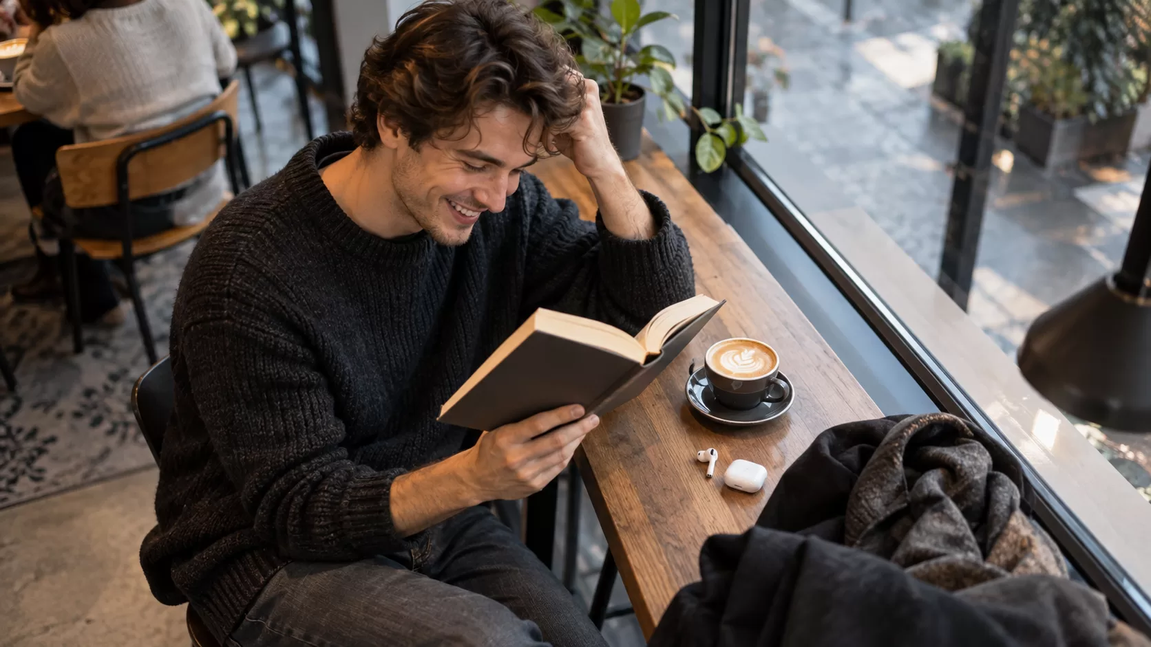Читатель смеётся над книгой в кафе